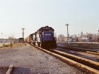 The cross-border transfer from Detroit's Livernois Yard - Conrail symbol LW-30a - is pulling hard up the grade out of the Detroit River tunnel. Just beyond the classic Michigan Central station, he will swing left through the crossover and continue to the yard. 
The mixed skyline in the distance is Windsor and Detroit, while to the left of the train, trucking company International Cartage has a healthy fleet of trailers.
Inside of 4 years this will become CN Windsor South and CR will have exited Ontario.
ETTS.