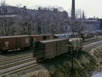 Canadian Pacific's Guelph yard job is seen working the "upper yard" in the city's downtown core along the Speed River.  While MLW S3 6586 moves about in the background, a trainman ties a handbrake on a cut of cars on the Goderich Sub main.

<br><br><i>Donald Coulman Photo, Jacob Patterson Collection Slide.</i>