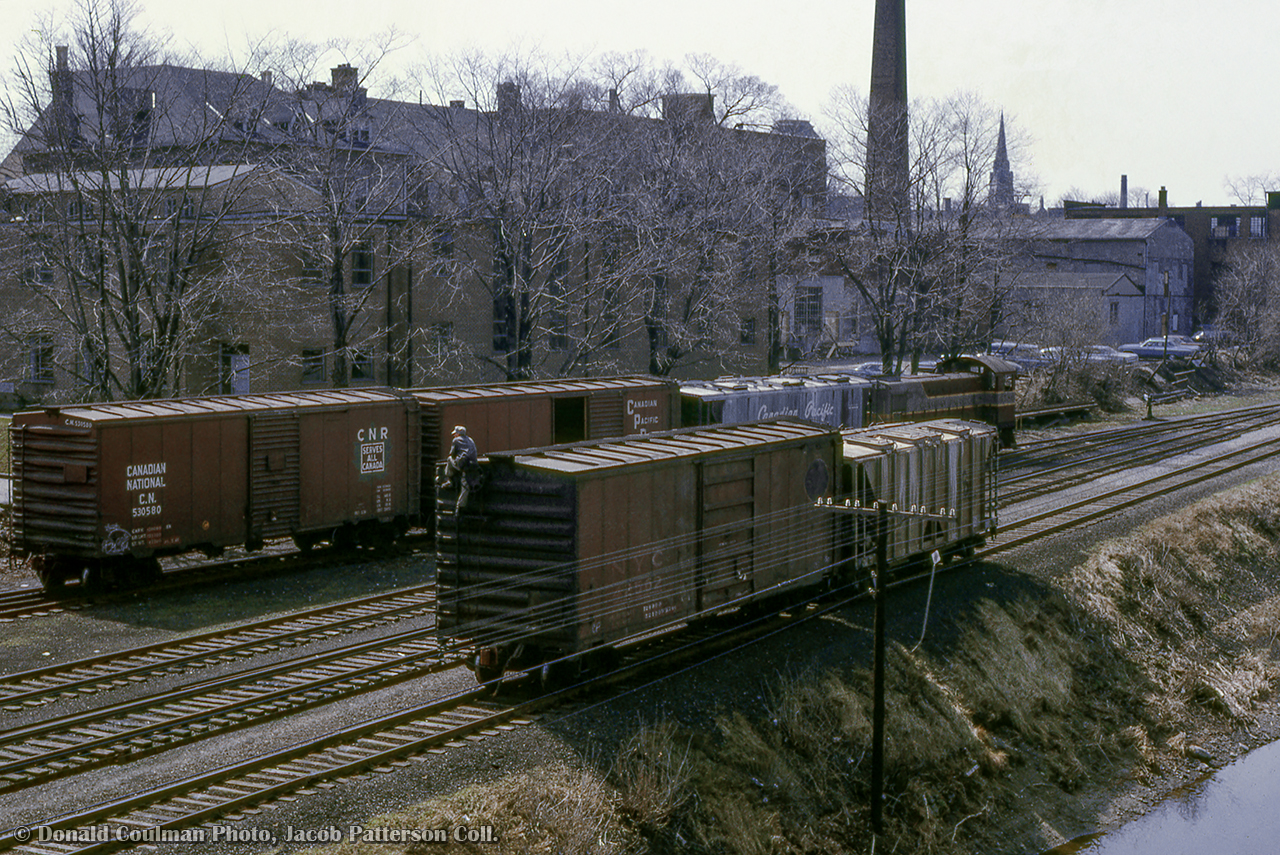 Canadian Pacific's Guelph yard job is seen working the "upper yard" in the city's downtown core along the Speed River.  While MLW S3 6586 moves about in the background, a trainman ties a handbrake on a cut of cars on the Goderich Sub main.

Donald Coulman Photo, Jacob Patterson Collection Slide.