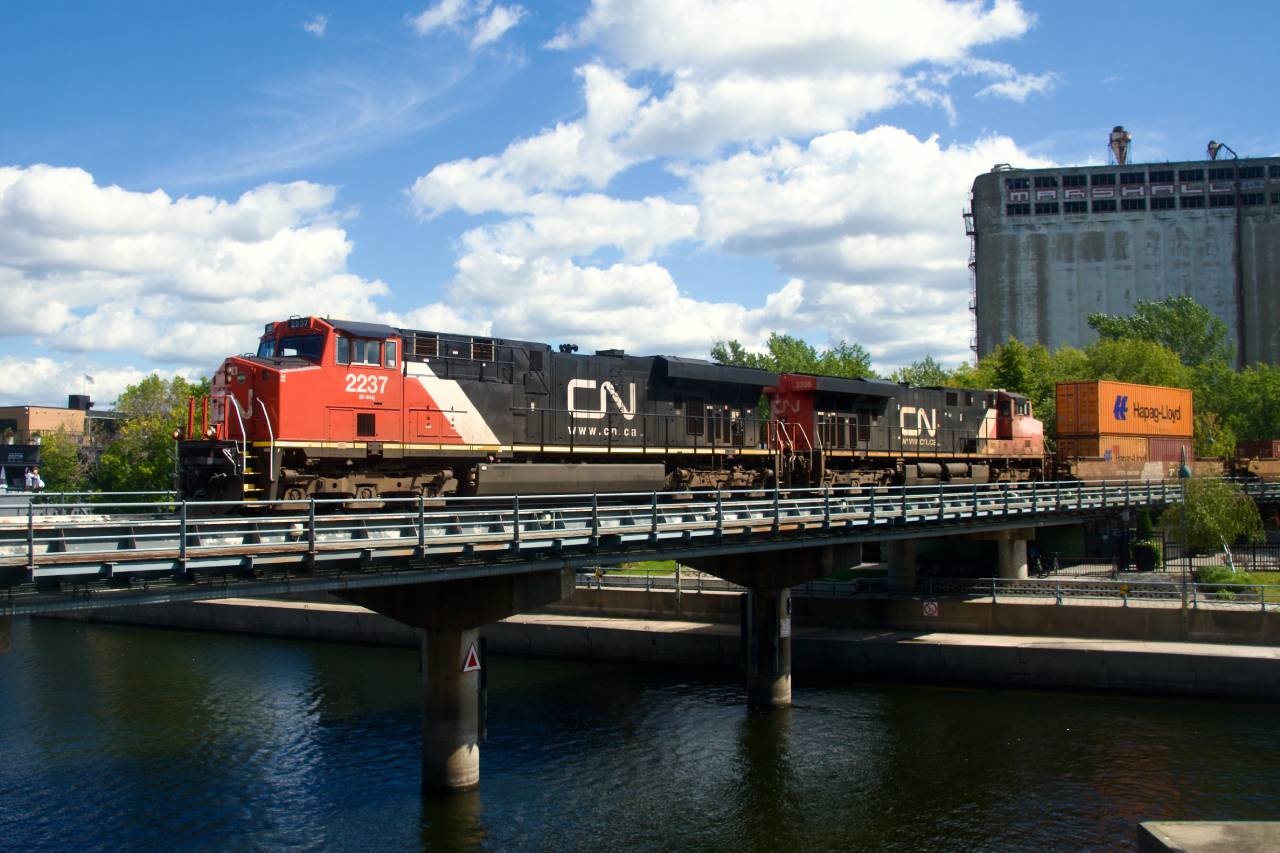 Consecutively numbered ES44DCs lead CN 126 into the Port of Montreal. Leader CN 2237 was damaged in a 2022 derailment (CN 327) and so has much less faded paint than the trailer.