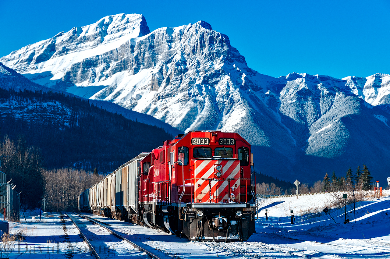 CP's Exshaw Switcher rests in the shadows of the Rocky Mountains, alongside the Laggan Sub awaiting a new crew to complete the return job of loads to Aylth Yard.