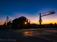 <B>Blenheim Blues, The Sequel.</b> Over 2 years ago I posted <a href="https://www.railpictures.ca/?attachment_id=55076"> an image from Blenheim</a> of CN 514 pulling cars from "Thompsons", know known as "The Andersons". Most sequels are never as good as the original but I'll be bias and say this sequel was better.<br><br> Like all sequels, building off the same story line as the previous, we start off with the ever so popular light power move. The crew ran light to Thamesville to switch out three cars that were part of the mainline's set off the night prior, run around said cars and spot them down the spur to Agris' "Crop Technology Centre". The crew would return light to Chatham, just beating VIA 78 to get the light down "The Spur". The slow, lumbering speed of 10 MPH afforded a number of shots along the way and the waning light afforded some unique lighting. <br> CN 514 arrived Blenheim right as the sun was setting and I was able to fire off this image of a dark sky and burning horizon as the conductor walked out on Chatham Street to protect the crossing as the veteran engine started out over the crossing. They will spend the next half hour switching cars at ADM Agri-Industries Company before running around their cars and returning for Chatham.
