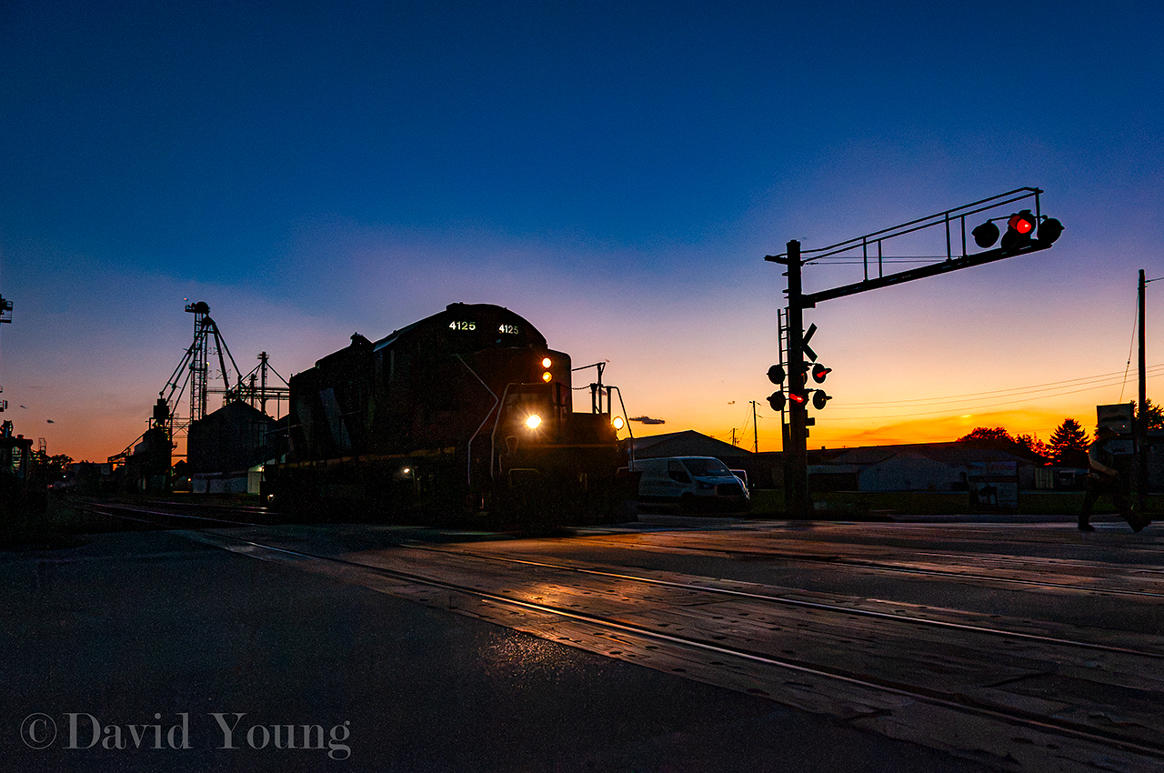 Blenheim Blues, The Sequel. Over 2 years ago I posted  an image from Blenheim of CN 514 pulling cars from "Thompsons", know known as "The Andersons". Most sequels are never as good as the original but I'll be bias and say this sequel was better. Like all sequels, building off the same story line as the previous, we start off with the ever so popular light power move. The crew ran light to Thamesville to switch out three cars that were part of the mainline's set off the night prior, run around said cars and spot them down the spur to Agris' "Crop Technology Centre". The crew would return light to Chatham, just beating VIA 78 to get the light down "The Spur". The slow, lumbering speed of 10 MPH afforded a number of shots along the way and the waning light afforded some unique lighting.  CN 514 arrived Blenheim right as the sun was setting and I was able to fire off this image of a dark sky and burning horizon as the conductor walked out on Chatham Street to protect the crossing as the veteran engine started out over the crossing. They will spend the next half hour switching cars at ADM Agri-Industries Company before running around their cars and returning for Chatham.