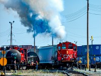 The crews of the two jobs working the west end of Sarcee Yard mingle while CN 7062 clears out the carbon pulling its track.
