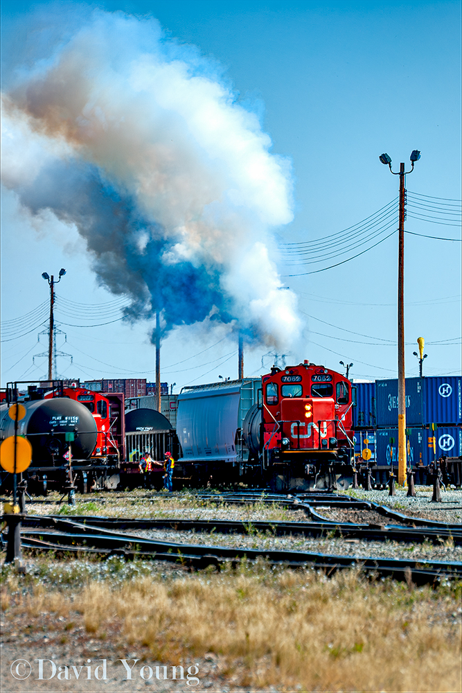 The crews of the two jobs working the west end of Sarcee Yard mingle while CN 7062 clears out the carbon pulling its track.