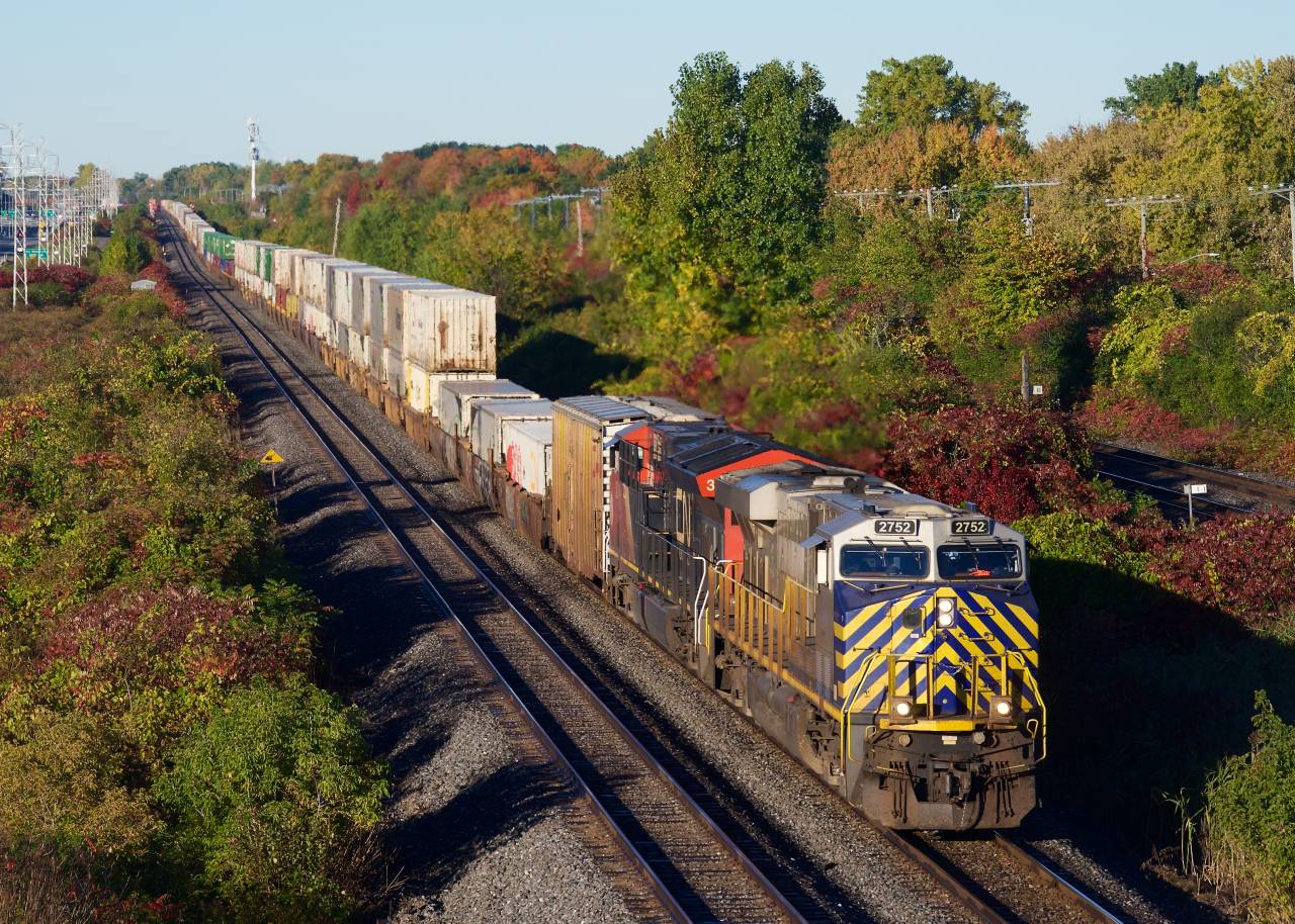 A slightly late CN 120 heads east through Beaconsfield with a test box car behind the power.