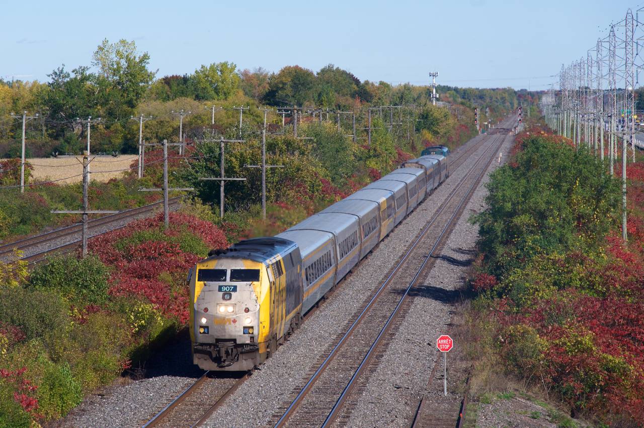 VIA 67 is westbound through Sainte-Anne-de-Bellevue with VIA 907 leading. A bilingual stop sign at right shows the end of track for a backtrack that is sometimes used for maintenance of way vehicles.