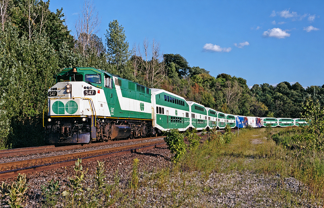 GO F59PH #547 rounds the bend by Kay Drage Park on the CP Hamilton Subdivision, on the way back to Willowbrook yard from Hamilton GO Centre with deadhead equipment.  During this time, all 3 daily GO trains to/from Hamiton GO Centre would deadhead from and to Willowbrook yard. Nowadays, there is a layover facility at the station, and these equipment moves are no longer necessary. The 547 was also among the last of GO's units to undergo an initial mid-life overhaul, and she certainly shows her external battle wounds in this picture.