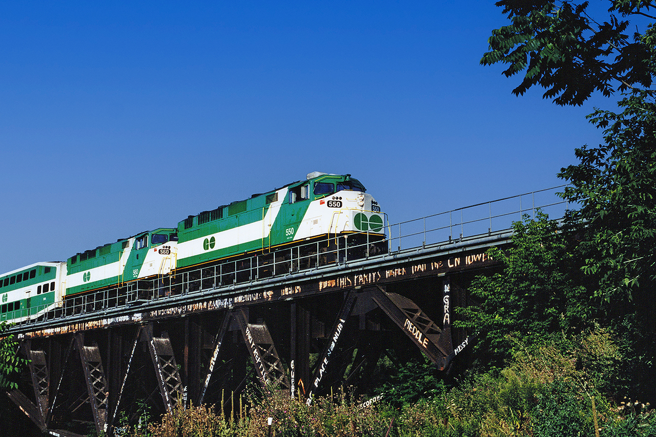 GO F59PHs #550 and 560 lead an eastbound Lakeshore West train across the Credit River into Port Credit, on a sunny Saturday morning in late August 2001. An extra locomotive was added to weekend consists on the Lakeshore Line (the only GO line with weekend train service back then) to keep the schedule and accommodate the larger (and slower to board) crowds during the CNE. The 550 had already undergone her mid-life overhaul and the 560 was about to do the same.
