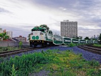 GO F59PH #564 brings a string of empty bilevels around the curve and into Hamilton GO Centre on a June morning in 1998. At the time, GO's three morning trains from Hamilton would be brought from Willowbrook Yard, two of them coupled together. The 564's train would be the last to depart on this day and as such, it was pulled past the platform to the east until the first train of the morning departed and vacated the inside track. Today, there is a storage yard for GO trains at this location and this equipment move is no longer necessary. 