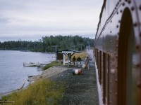 Algoma Central Railway train 2, running Hearst - Sault St. Marie, pauses at Wabatong near mile 207.  Passengers are seen gathering their belongings from beneath the shelter on the shore of Wabatongushi Lake, passing them to the baggage handler before climbing aboard.

<br><br><a href=https://www.railpictures.ca/?attachment_id=54251>Pausing at Oba</a>
<br><a href=https://www.railpictures.ca/?attachment_id=59048>The head end</a>
<br><a href=https://www.railpictures.ca/?attachment_id=59651>ACR meets CN</a>
<br><a href=https://www.railpictures.ca/?attachment_id=60063>New GP35s</a>
<br><a href=https://www.railpictures.ca/?attachment_id=60069>South of Mosher</a>

<br><br><i>Scan and editing by Jacob Patterson.</i>