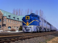 Operating Montreal – New York, Delaware & Hudson train 34, <i>The Laurentian,</i> pauses in front of the <a href=https://www.railpictures.ca/?attachment_id=26582>Napierville Junction Railway</a> station at Lacolle, Quebec.  Built in 1930, this structure served as a station and customs office for the NJR and later the D&H.

<br><br>The D&H had operated passenger service into Montreal since 1923 with both its Laurentian by day and Montreal Limited overnight. These operated into Canada over D&H subsidiary, Napierville Junction Railway, running 27 miles from Rouses Point, New York - Delson and into Montreal via CPR trackage rights. Endangered by declining ridership by the 1960s, new management in the D&H's passenger department sought to revitalize the operation after negative public response to the potential cancellation. To do so, the D&H acquired four ALCO PA-1 locomotives in 1967, <a href=https://www.railpictures.net/photo/484399>numbered 16 - 19, from the ATSF.</a> Wearing a modified ATSF Warbonnet scheme, with D&H blue replacing the red, they would handle the trains of second hand equipment until their final runs on April 30, 1971, as neither The Laurentian or Montreal Limited were included in Amtrak's start up.  In 1974, passenger service over the D&H was to be resurrected by Amtrak as The Adirondack, funded by the New York Department of Transportation. With limited equipment available to Amtrak at the time, the D&H, then led by Carl Sterzing, provided its PAs and passenger equipment for the runs. For their return to passenger operation the PAs would be rebuilt from their original ALCO 244 prime mover to ALCO 251s in 1974 by Morrison-Knudsen, and designated ALCO PA-4s. The rebuilt units served until 1977 when Amtrak replaced the D&H equipment with <a href=http://www.railpictures.ca/?attachment_id=45337>Rohr Turboliners.</a> It is also noted, the D&H had acquired a fifth PA for parts in the 1960s, <a href=https://www.railpictures.net/viewphoto.php?id=481754>former New Haven 0783.</a> It was scraped in 1972.

<br><br>The last passenger train to stop at Lacolle would be in April 1985, when Amtrak’s Adirondak was rerouted from CP Windsor Station to CN/VIA Rail Gare Centrale, taking CN’s Rouses Point Subdivision through Cantic a few miles to the east.  Lacolle station <a href=https://www.railpictures.ca/?attachment_id=46773>still stands today,</a> designated a heritage railway station in 1991.

<br><br>More D&H PA Canadian action:
<br><a href=https://www.railpictures.ca/?attachment_id=10875>D&H 16 near Montreal West</a>
<br><a href=https://www.railpictures.ca/?attachment_id=10874>D&H 18 at Montreal West</a>
<br><a href=https://www.railpictures.ca/?attachment_id=12195>D&H 18 at Westmount</a>
<br><a href=https://www.railpictures.ca/?attachment_id=49629>Windsor Station 1975</a>

<br><br><i>Scan and editing by Jacob Patterson.</i>


