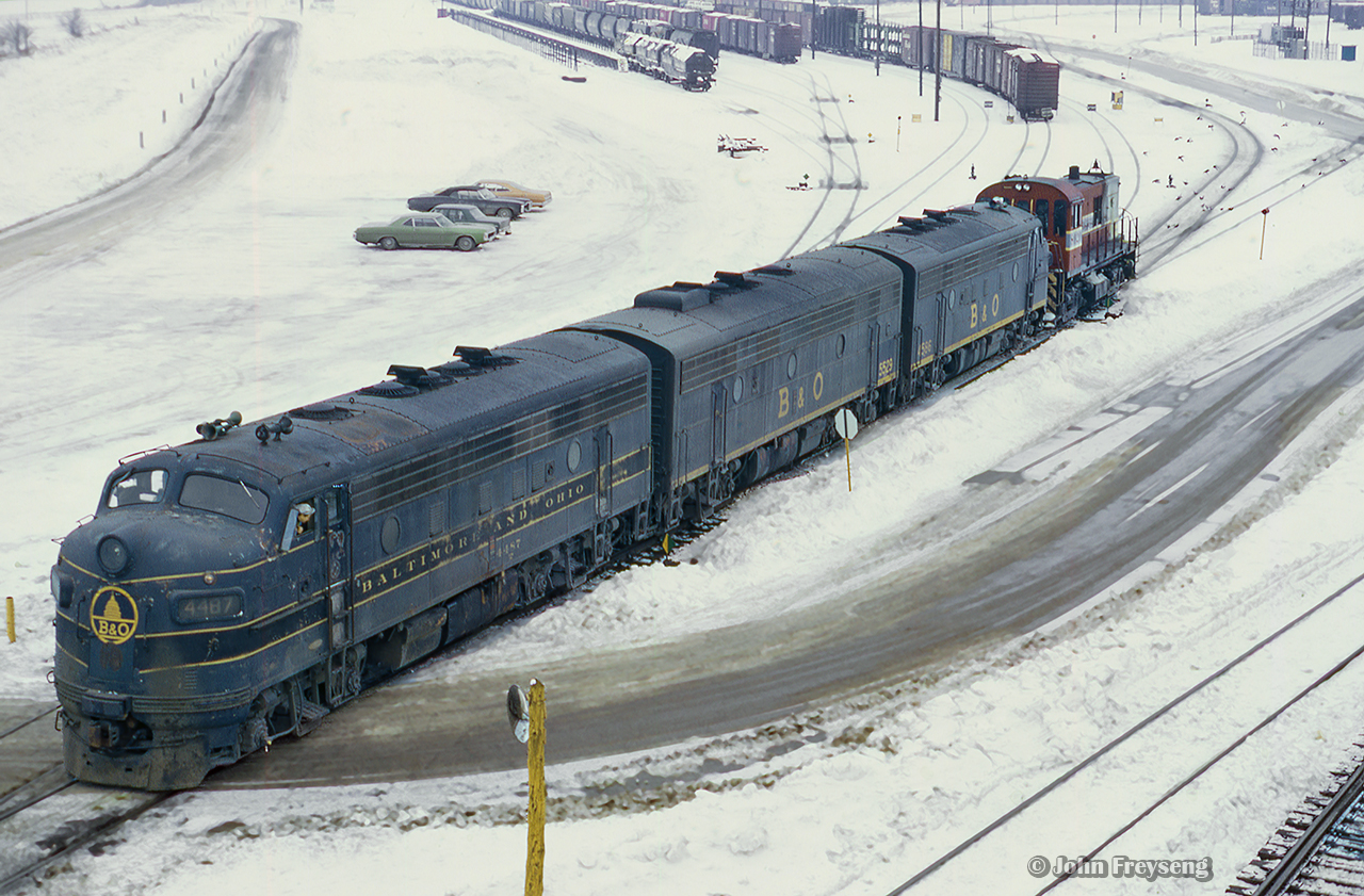 Cut off from their train, Extra B&O 4487 (class lights lit) moves through the east end of the yard near Finch Avenue. Taken in mid-late February, the lease of B&O F units began only just before this on February 10, 1972.  More information on the lease of B&O F units can be found here.

Extra 4487 approaching Agincourt station
Extra 4487 passing through Agincourt station

Scan and editing by Jacob Patterson.