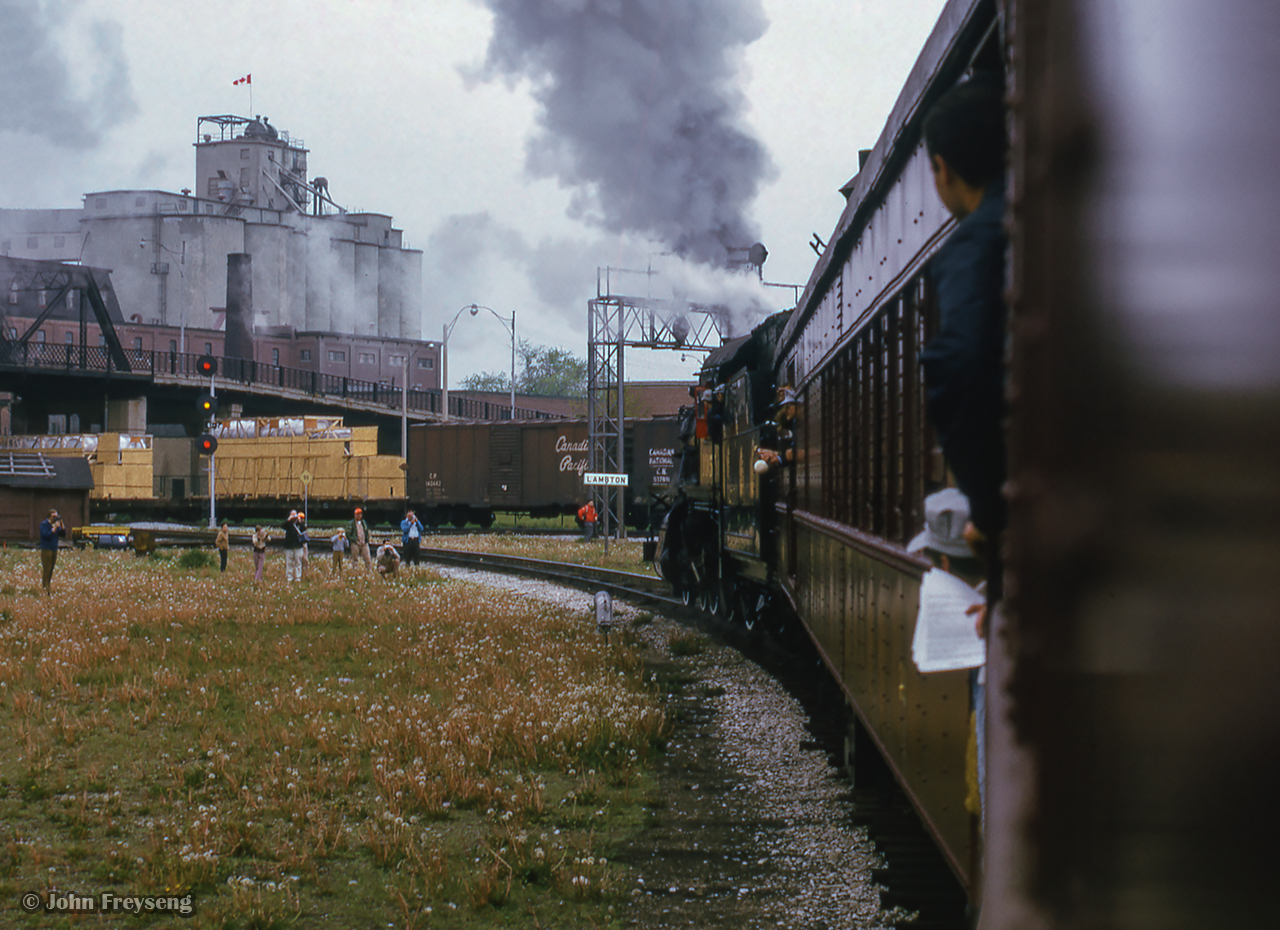 Departing West Toronto station, an Ontario Rail Association trip to Orangeville behind ex CPR D10 1057 swings through the Galt Sub curve at the Lambton mileboard.  Local industries, a passing freight, and the Weston Road overpass complete the scene.


Scan and editing by Jacob Patterson.