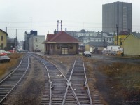 Looking back from the rear of CN passenger extra 3151, a view of Waterloo's 1910 Grand Trunk Railway station at Regina Street, today the home of Paul Puncher Men's Clothier.  Towering over the scene at right is the Marsland Centre building, having opened a few years earlier in 1971.  Likely operated by the Ontario Rail Association, the extra is slowly returning to the Guelph Sub and ultimately Toronto Union Station after paying a visit to the Elmira Maple Syrup Festival.<br><br><a href=https://www.railpictures.ca/?attachment_id=55371>Tempo units at Elmira (1)</a><br><a href=https://www.railpictures.ca/?attachment_id=58887>Tempo units at Elmira (2)</a><br><a href=https://www.railpictures.ca/?attachment_id=59801>Uptown Waterloo</a><br><a href=https://www.railpictures.ca/?attachment_id=47842>Waterloo station, 1982</a><br><a href=https://www.railpictures.ca/?attachment_id=51050>CN 1530 Job, 1993</a><br><a href=https://www.railpictures.ca/?attachment_id=44046>CN 1530 Job, 1997</a><br><br><i>Scan and editing by Jacob Patterson.</i>