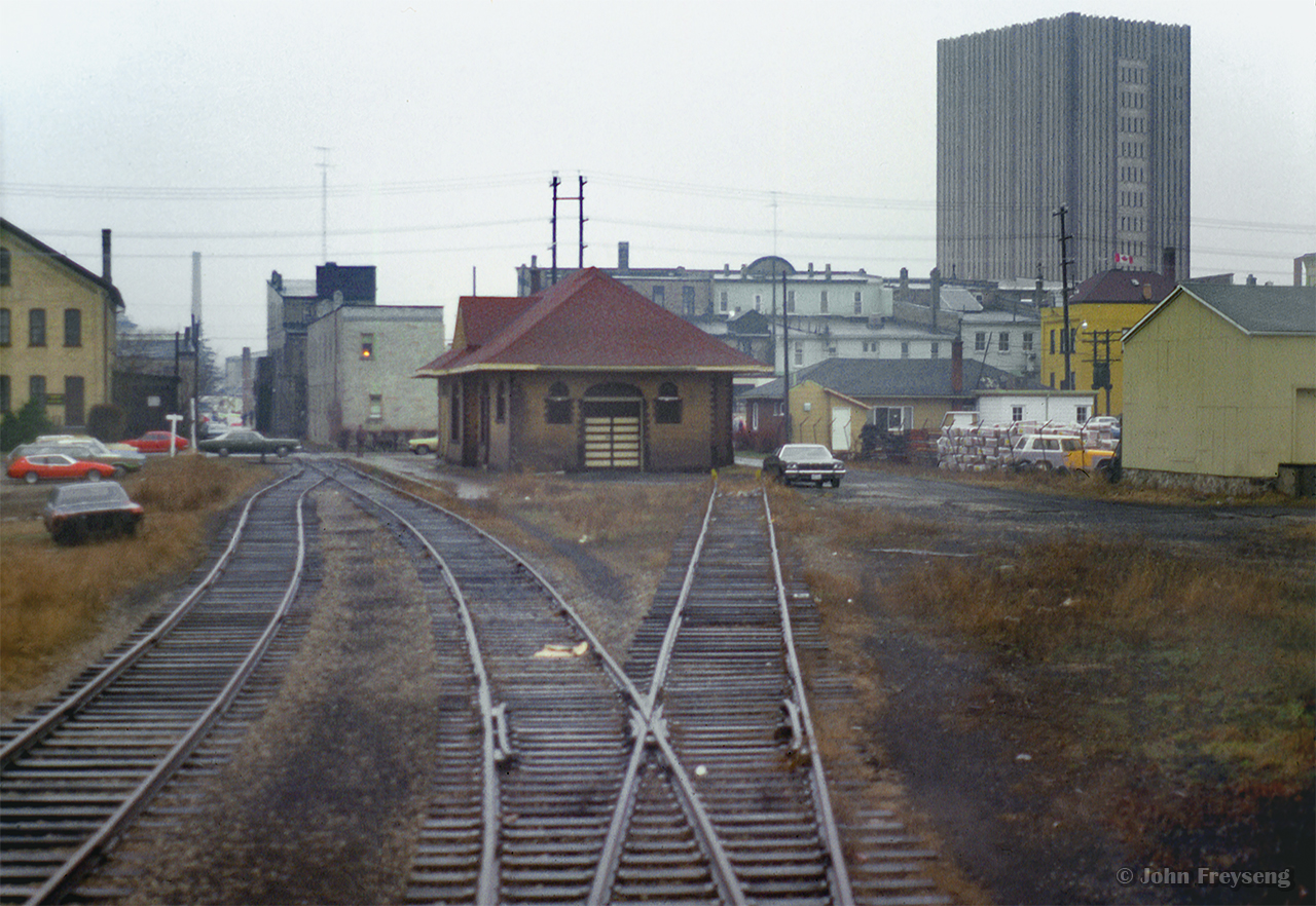 Looking back from the rear of CN passenger extra 3151, a view of Waterloo's 1910 Grand Trunk Railway station at Regina Street, today the home of Paul Puncher Men's Clothier.  Towering over the scene at right is the Marsland Centre building, having opened a few years earlier in 1971.  Likely operated by the Ontario Rail Association, the extra is slowly returning to the Guelph Sub and ultimately Toronto Union Station after paying a visit to the Elmira Maple Syrup Festival.

Tempo units at Elmira (1)
Tempo units at Elmira (2)
Uptown Waterloo
Waterloo station, 1982
CN 1530 Job, 1993
CN 1539 Job, 1997

Scan and editing by Jacob Patterson.