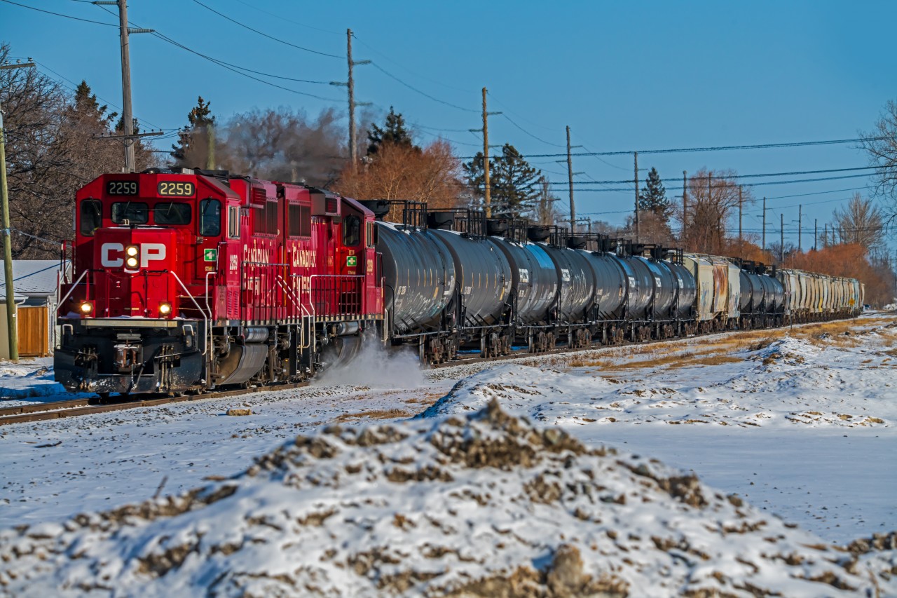 A small mixed train heading through the River Heights neighborhood on the way to the South end of the city.