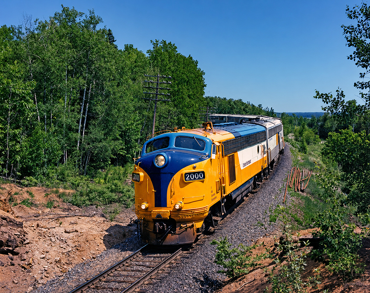 Ontario Northland FP7ACat #2000 leads the northbound "Northlander" out of North Bay, on a clear June day in 1995. This F-unit had been recently rebuilt from FP7A #1502- the original GMD motor was replaced with a Caterpillar prime mover, which proved to be more cantankerous than originally hoped for. Two other FP7s would undergo the rebuild program and although they looked great, they did not remain in service past the early 2000s. The overhaul program was very in-depth and included a complete overhaul of the engine and electrical systems, as well as installation of desktop controls. It's a shame the ONR didn't opt to just keep the original GMD prime mover as their GP9s that shared the same platform are still in use as of this posting.
