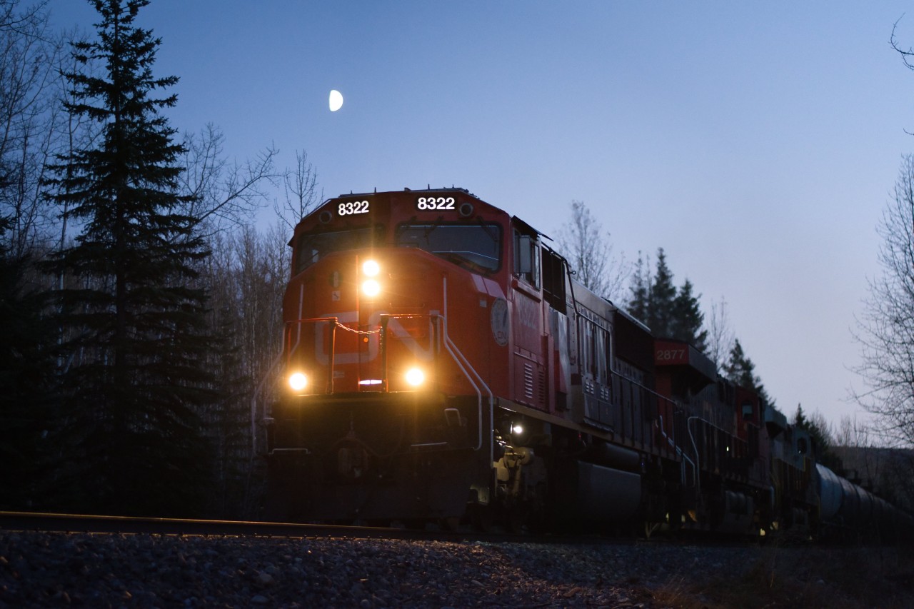 CN 8322 leads a northbound manifest train north to Fort St John under a half moon.