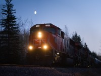 CN 8322 leads a northbound manifest train north to Fort St John under a half moon. 